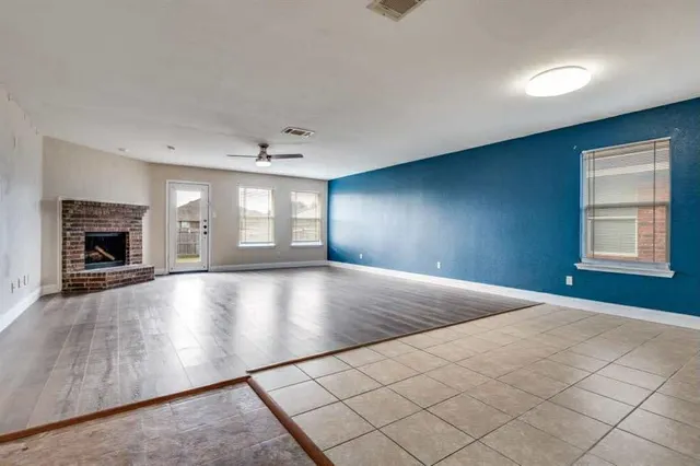 a view of empty room with wooden floor and fireplace
