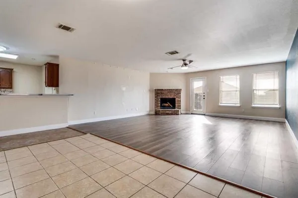 an empty room with windows and fireplace