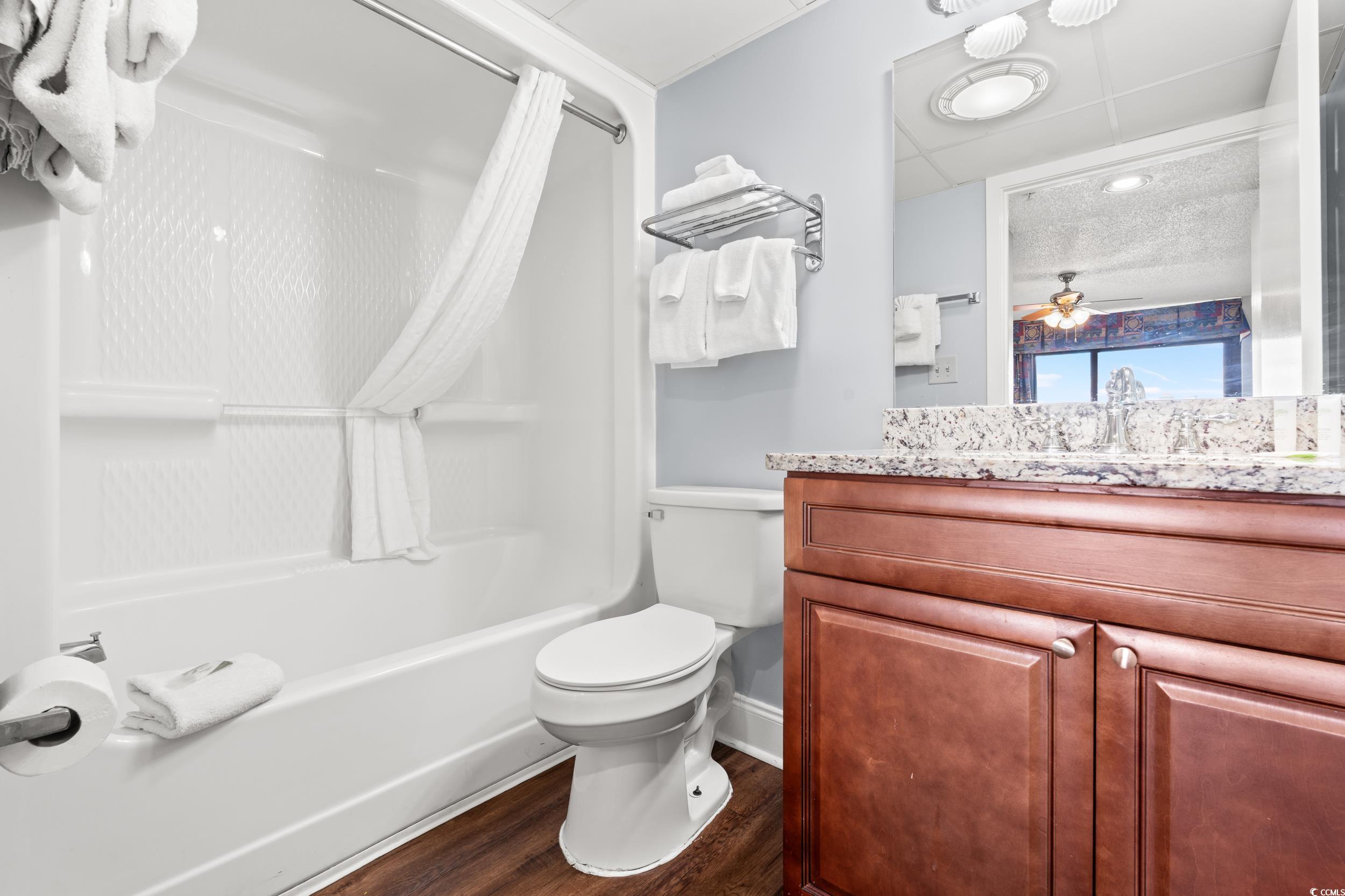 201N 74th Avenue North, Unit 601 Myrtle Beach, SC 29572 - Photo 11 of 35 Bathroom featuring dark wood-type flooring, shower / bathtub combination with curtain, vanity, and a ceiling fan