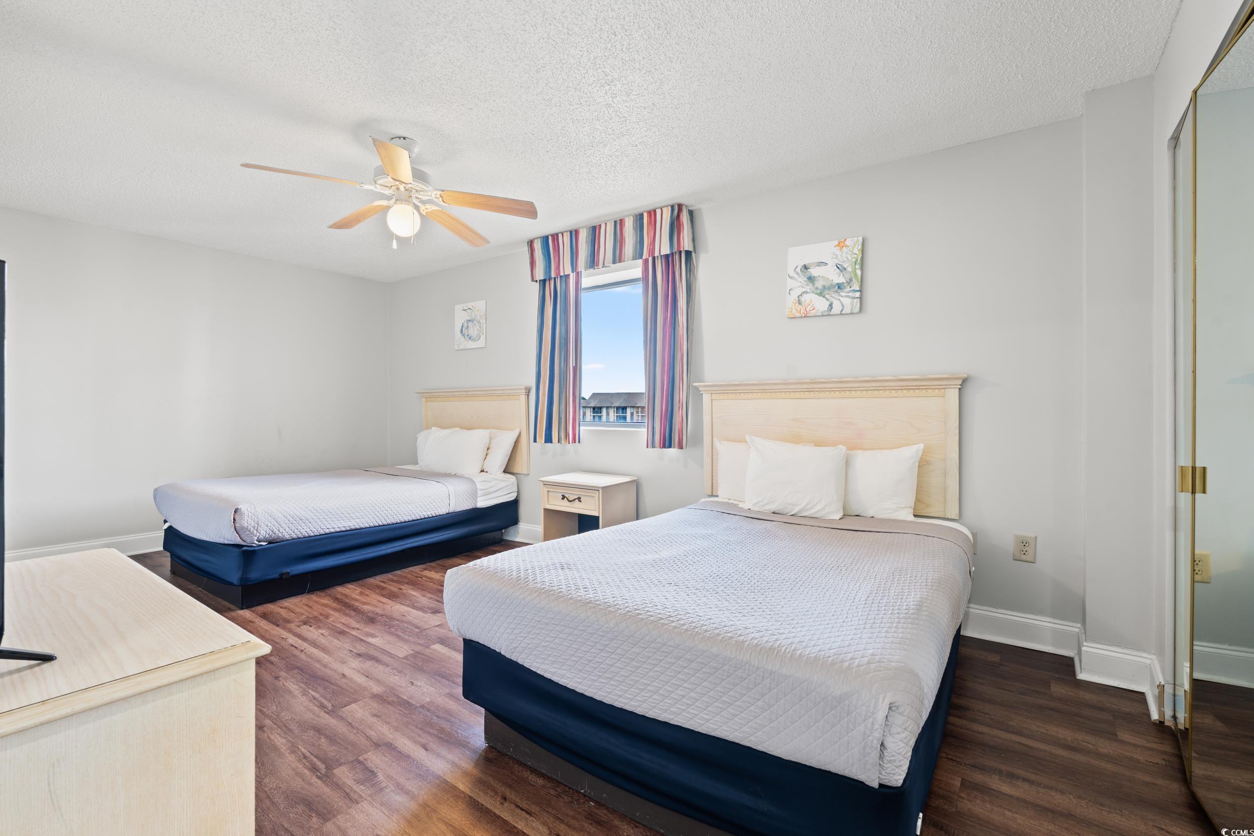 201N 74th Avenue North, Unit 601 Myrtle Beach, SC 29572 - Photo 12 of 35 Bedroom featuring a closet, dark wood-style flooring, a textured ceiling, and ceiling fan