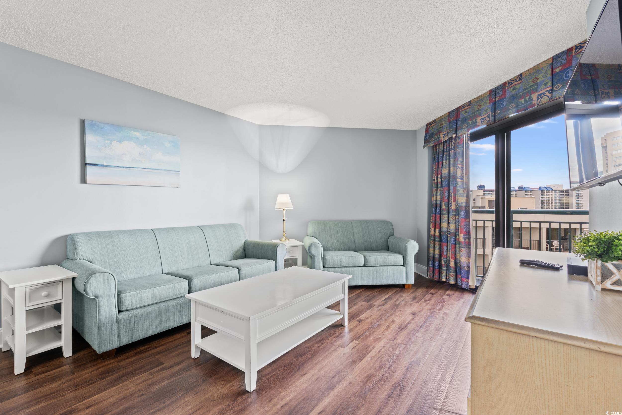 201N 74th Avenue North, Unit 601 Myrtle Beach, SC 29572 - Photo 2 of 35 Living area featuring a textured ceiling, wood finished floors, and an office area