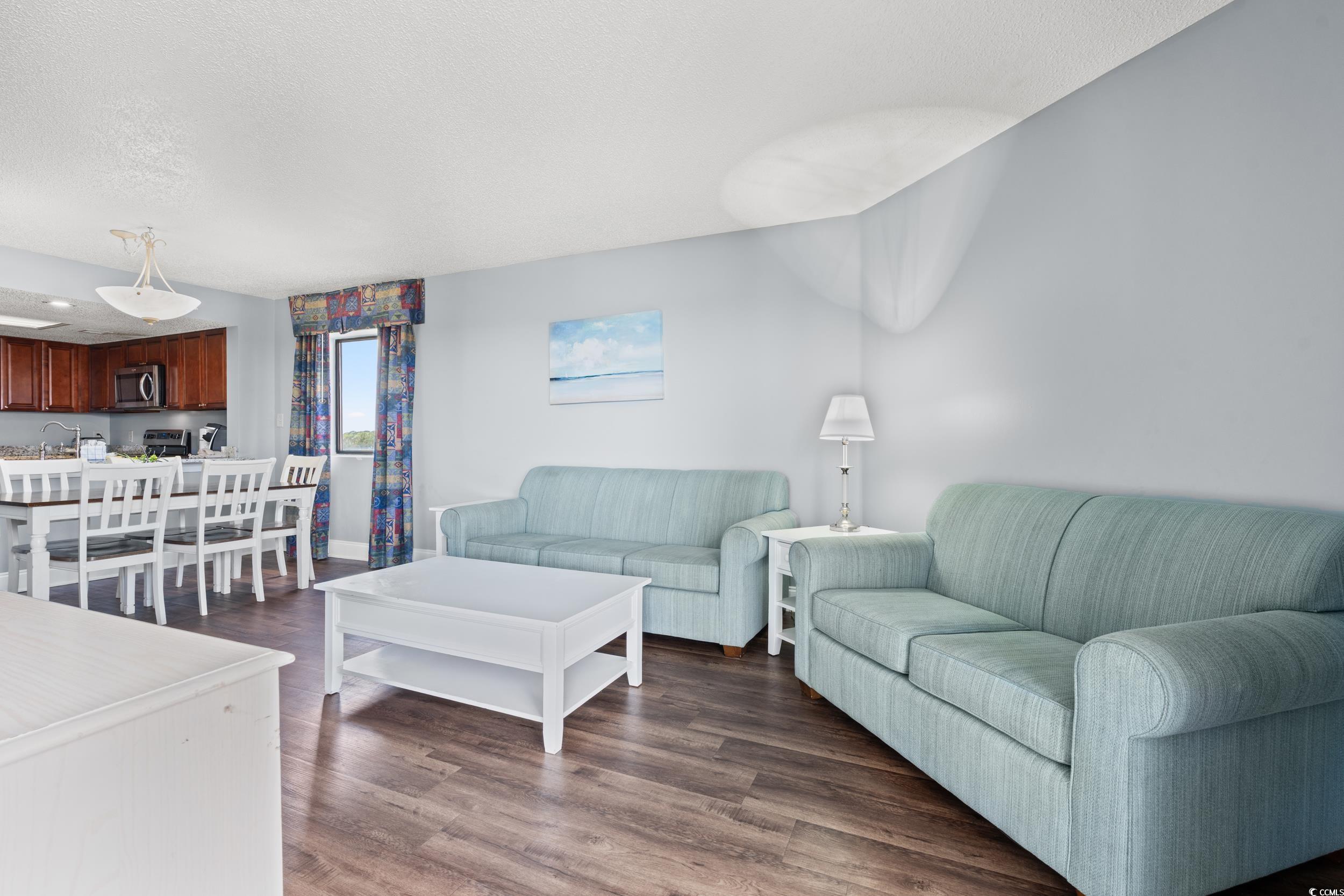 201N 74th Avenue North, Unit 601 Myrtle Beach, SC 29572 - Photo 4 of 35 Living area with dark wood-style floors and a textured ceiling