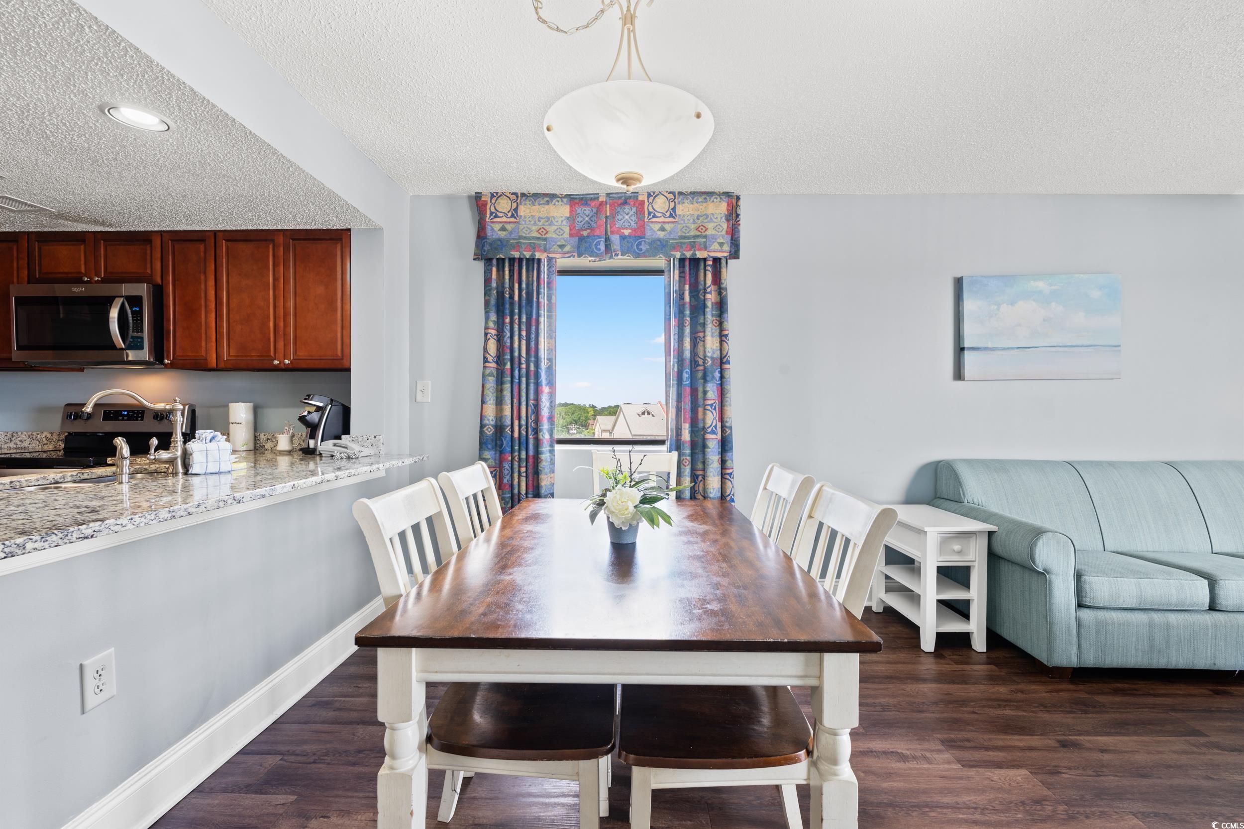 201N 74th Avenue North, Unit 601 Myrtle Beach, SC 29572 - Photo 5 of 35 Dining room featuring a textured ceiling and dark wood-style floors