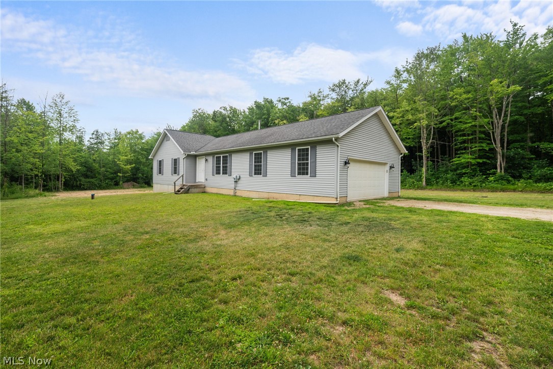 16985 Moseley Road Thompson, OH 44086 - Photo 2 of 22 Ranch-style home featuring a garage and a front yard