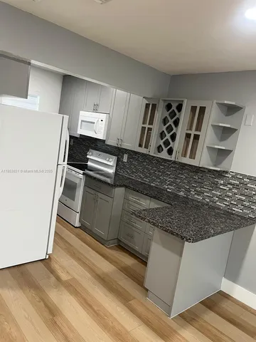 a kitchen with granite countertop a refrigerator and a stove