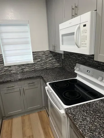 a kitchen with granite countertop a sink and a stove