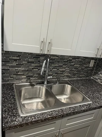 a close view of sink a faucet a washer and dryer