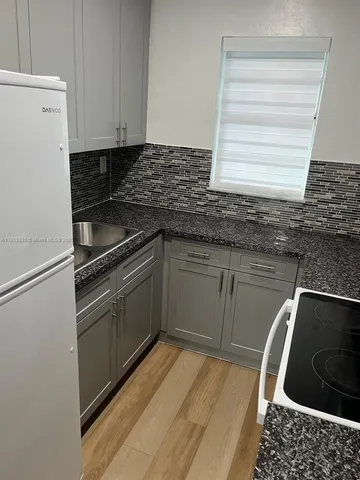 a kitchen with granite countertop a sink stainless steel appliances and cabinets
