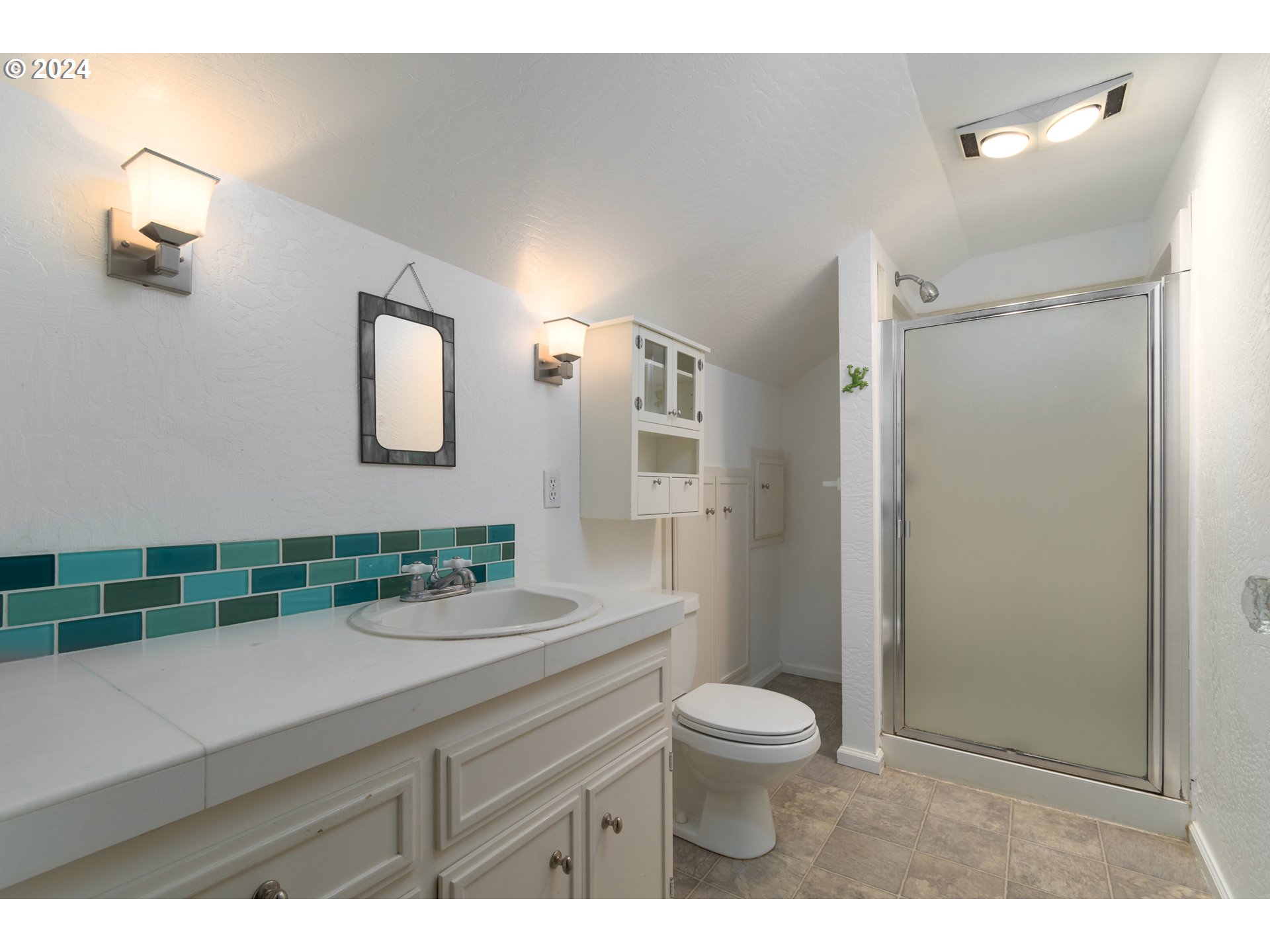 2614 Van Ness Street Eugene, OR 97403 - Photo 23 of 38 a bathroom with a sink a toilet a shower and a mirror