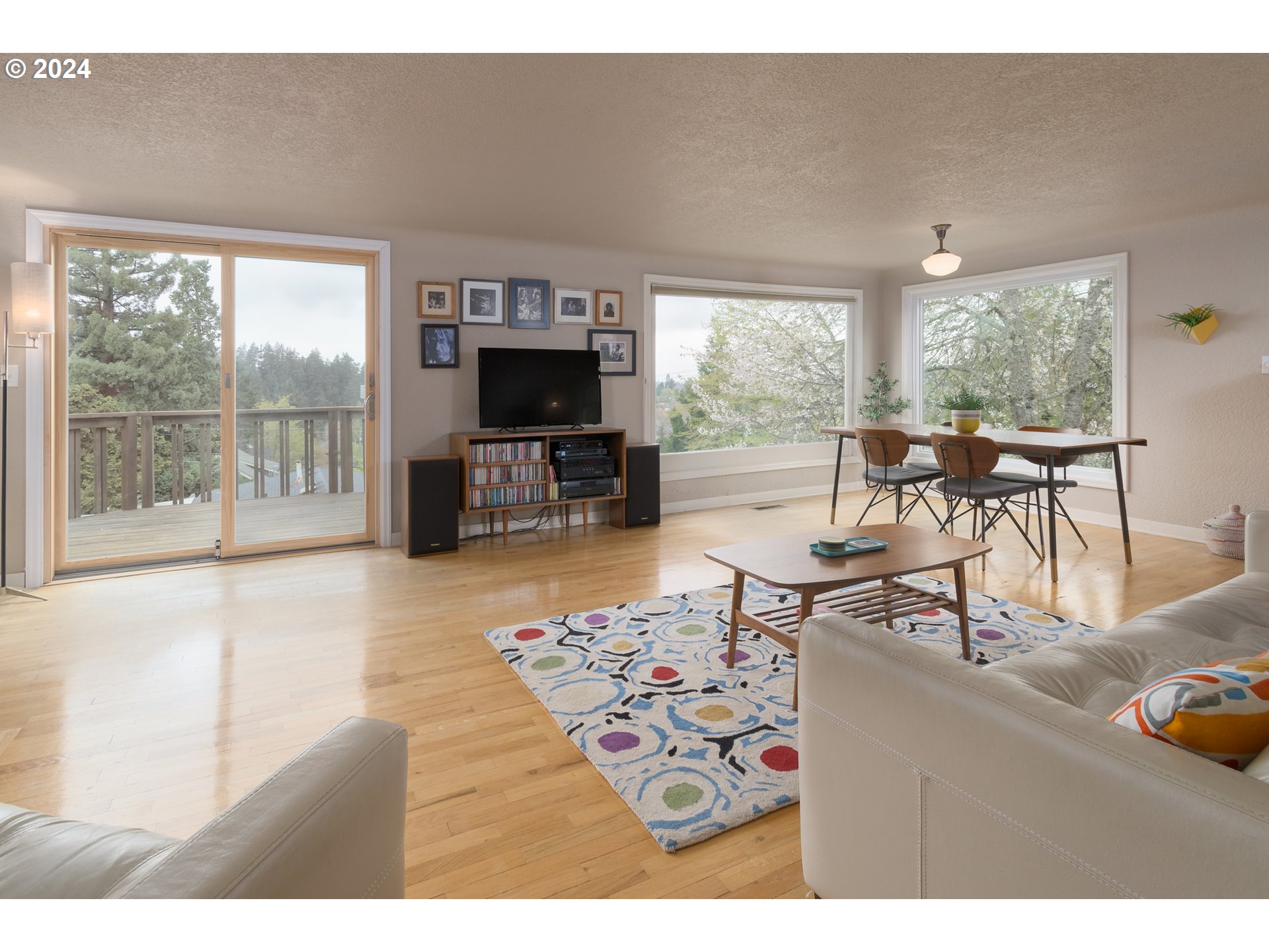 2614 Van Ness Street Eugene, OR 97403 - Photo 5 of 38 a living room with furniture a flat screen tv and a floor to ceiling window