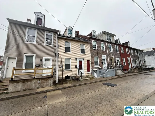 a front view of a house with a road