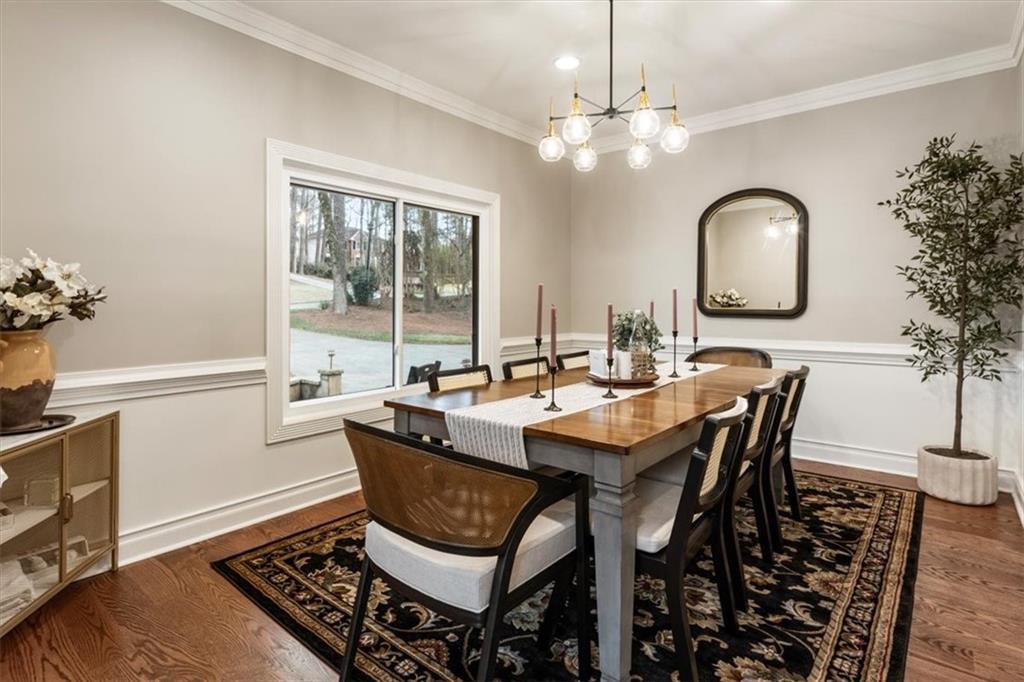 2415 Roxburgh Drive Roswell, GA 30076 - Photo 12 of 62 a dining room with wooden floor a chandelier a wooden table and chairs