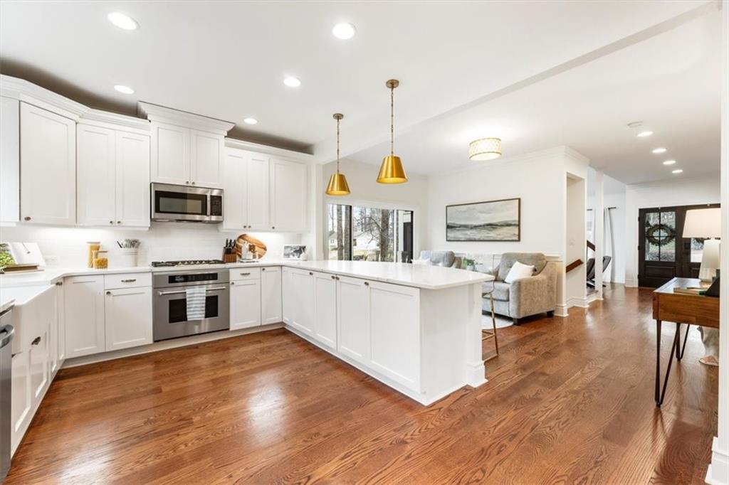 2415 Roxburgh Drive Roswell, GA 30076 - Photo 16 of 62 a kitchen with stainless steel appliances granite countertop a stove top oven a sink dishwasher a dining table and chairs with wooden floor