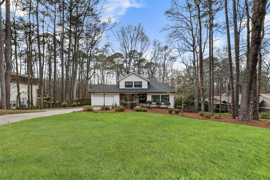 2415 Roxburgh Drive Roswell, GA 30076 - Photo 4 of 62 a view of a house with a big yard and large trees