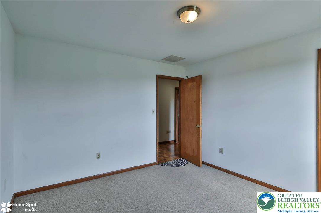 829 Georgetown Road Nazareth, PA 18064 - Photo 33 of 54 A spacious bedroom presents neutral walls, wood trim, and classic carpeting.