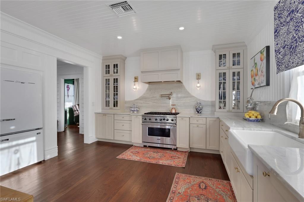 2582 First Street Fort Myers, FL 33901 - Photo 13 of 35 a kitchen with granite countertop a stove top oven a sink dishwasher and a refrigerator with wooden floor