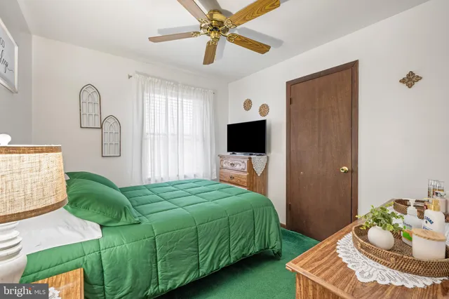 a living room with a bed furniture and a flat screen tv