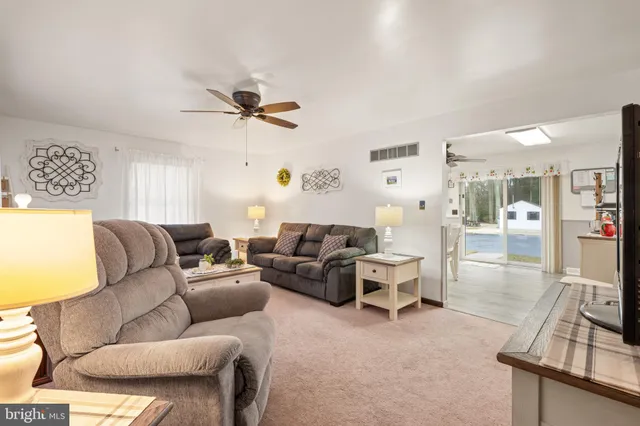 a living room with furniture a ceiling fan and a rug