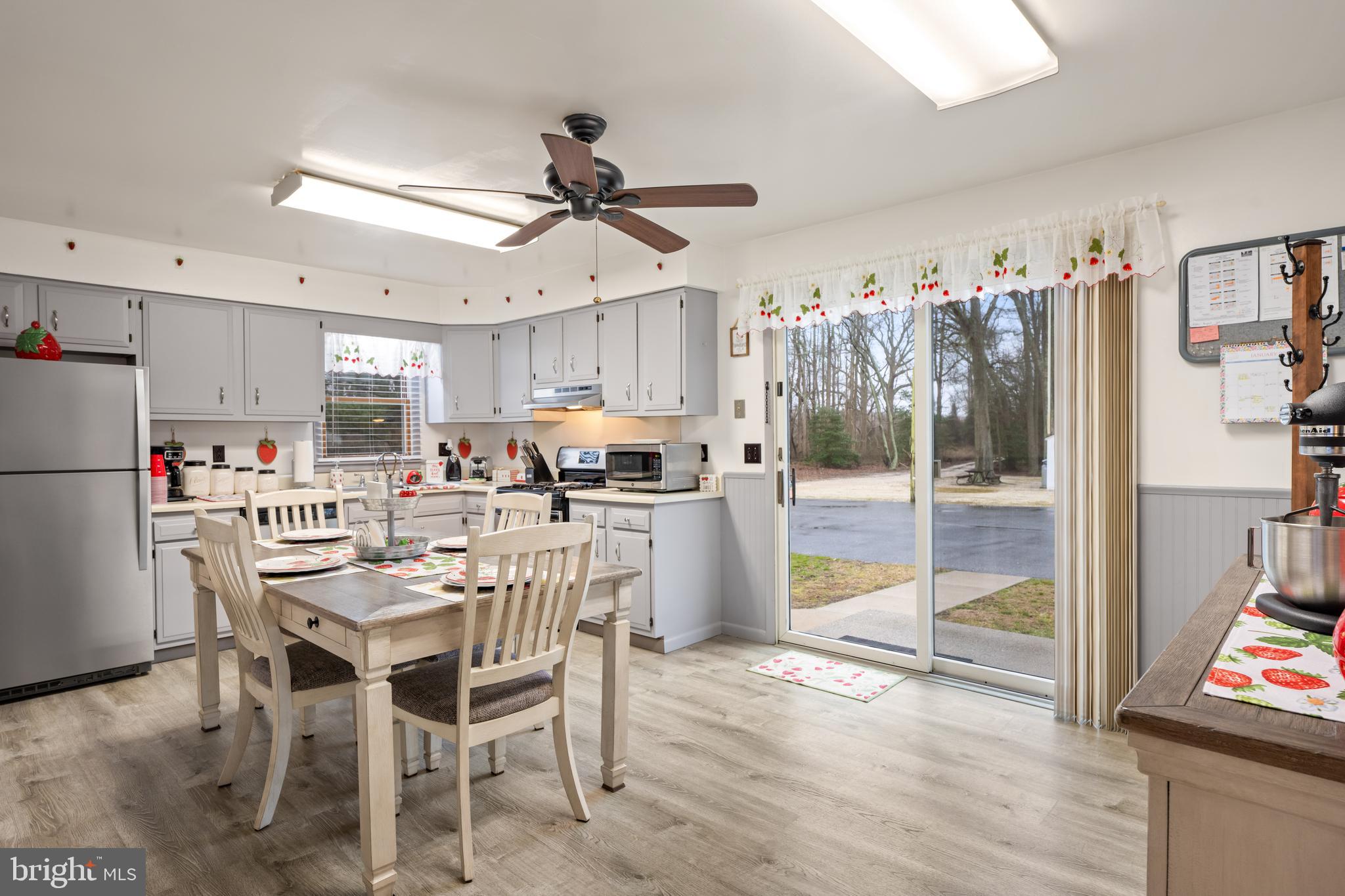 393 Newport Neck Road Newport, NJ 08345 - Photo 5 of 24 a kitchen with stainless steel appliances a dining table chairs and white cabinets