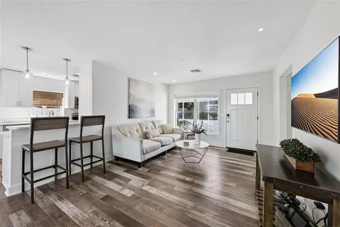 a living room with furniture wooden floor and a table