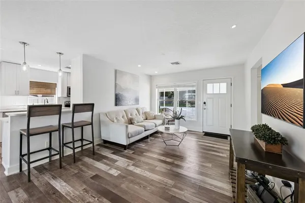 a living room with furniture wooden floor and a table