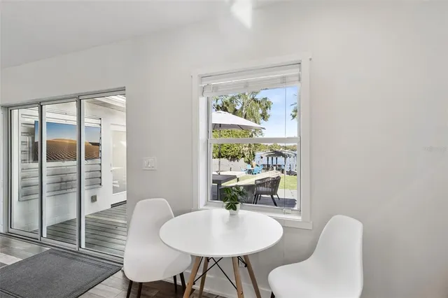 a dining room with furniture a rug and a large window