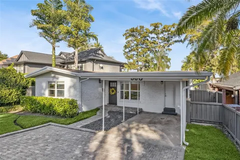a view of a house with a yard and potted plants