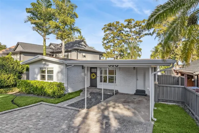 a view of a house with a yard and potted plants