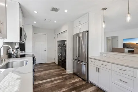 a kitchen with refrigerator cabinets and a sink