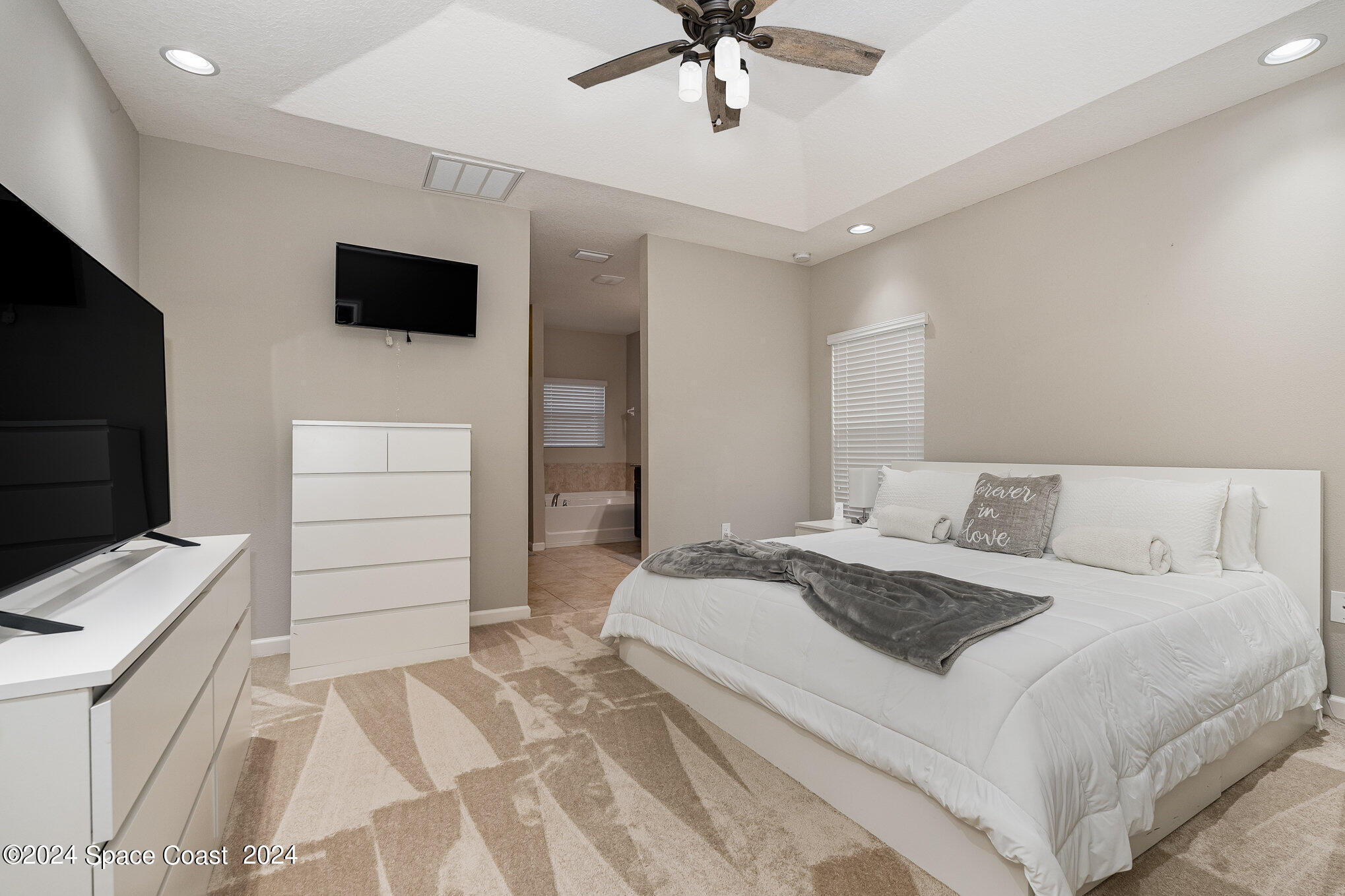 4210 Harvest Circle Rockledge, FL 32955 - Photo 12 of 24 a bedroom with a bed and a flat screen tv