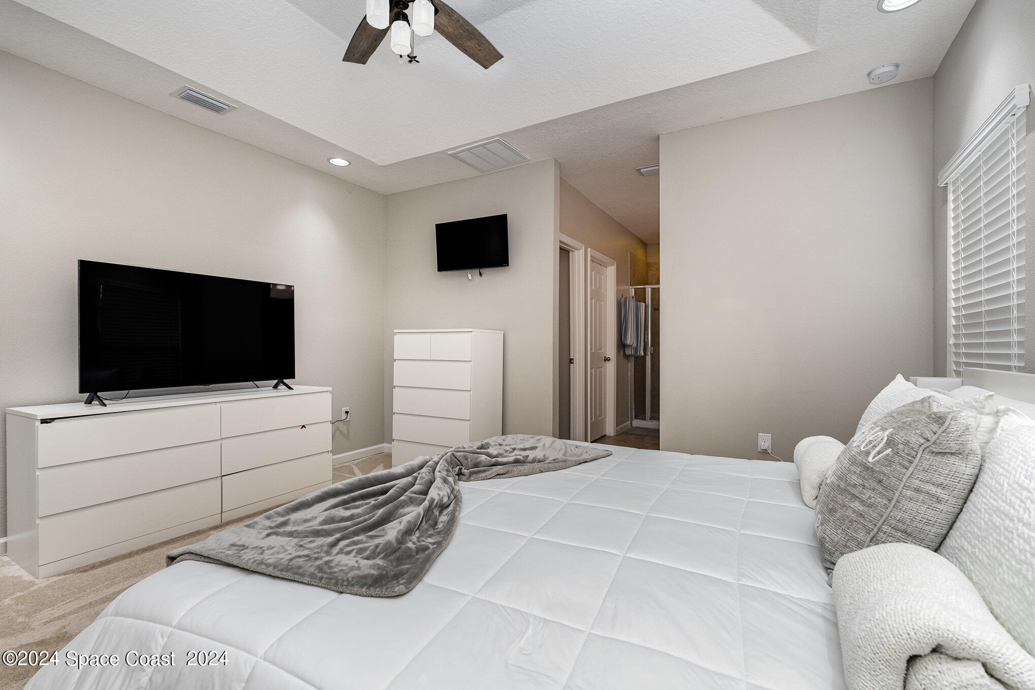 4210 Harvest Circle Rockledge, FL 32955 - Photo 13 of 24 a bedroom with a bed a flat screen tv and a couch
