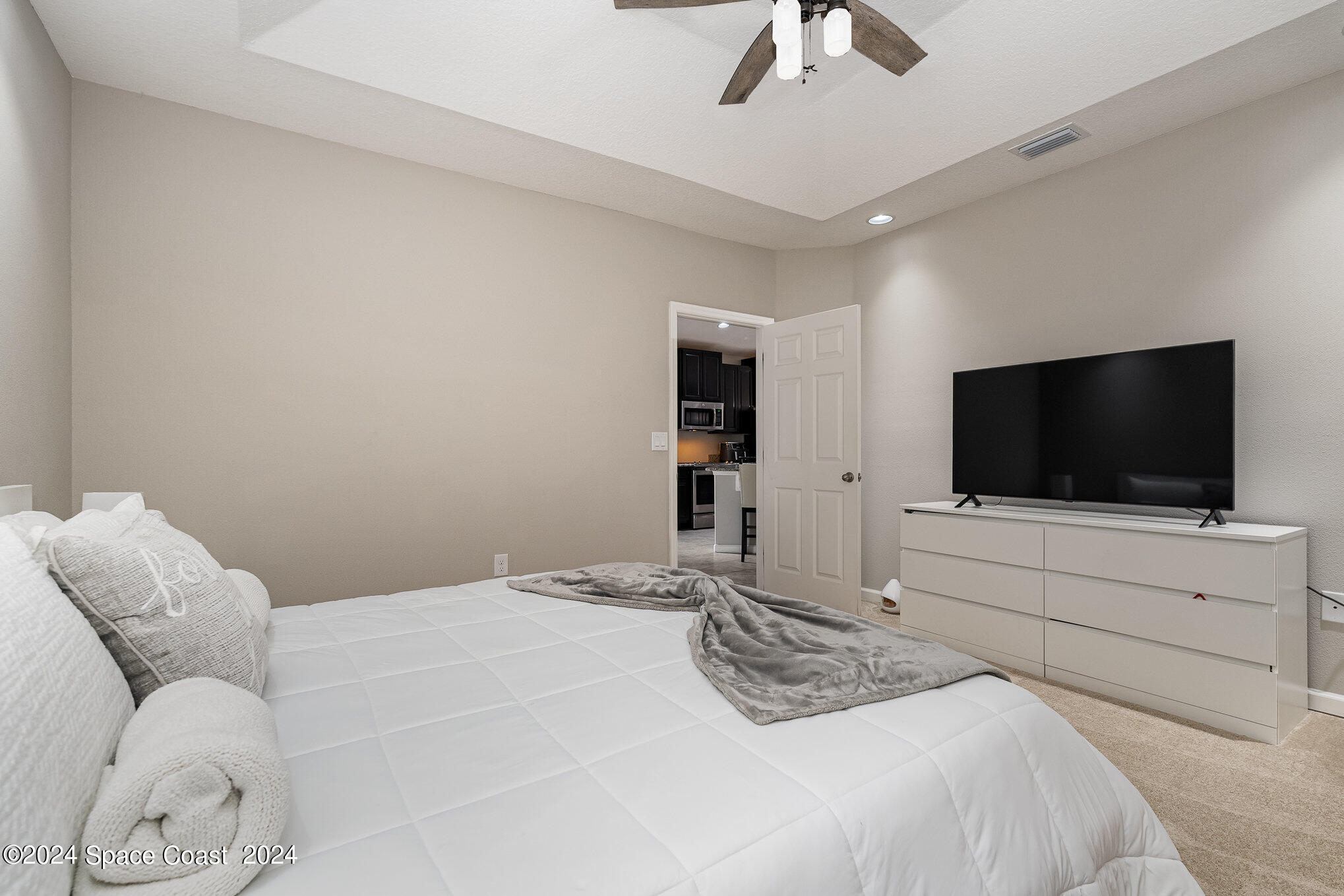 4210 Harvest Circle Rockledge, FL 32955 - Photo 14 of 24 a bedroom with a bed and a flat screen tv