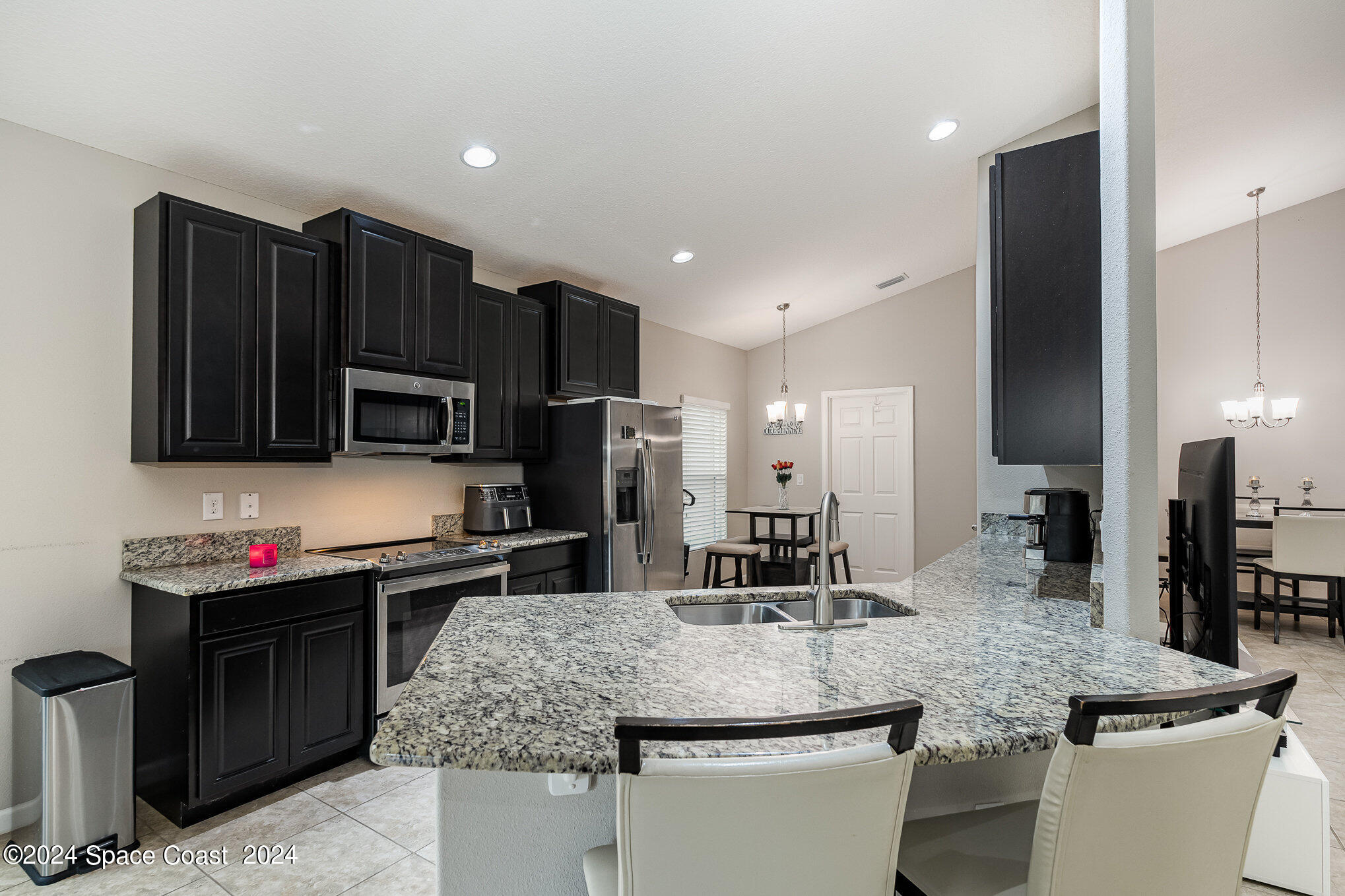 4210 Harvest Circle Rockledge, FL 32955 - Photo 8 of 24 a kitchen with stainless steel appliances granite countertop a sink and a refrigerator