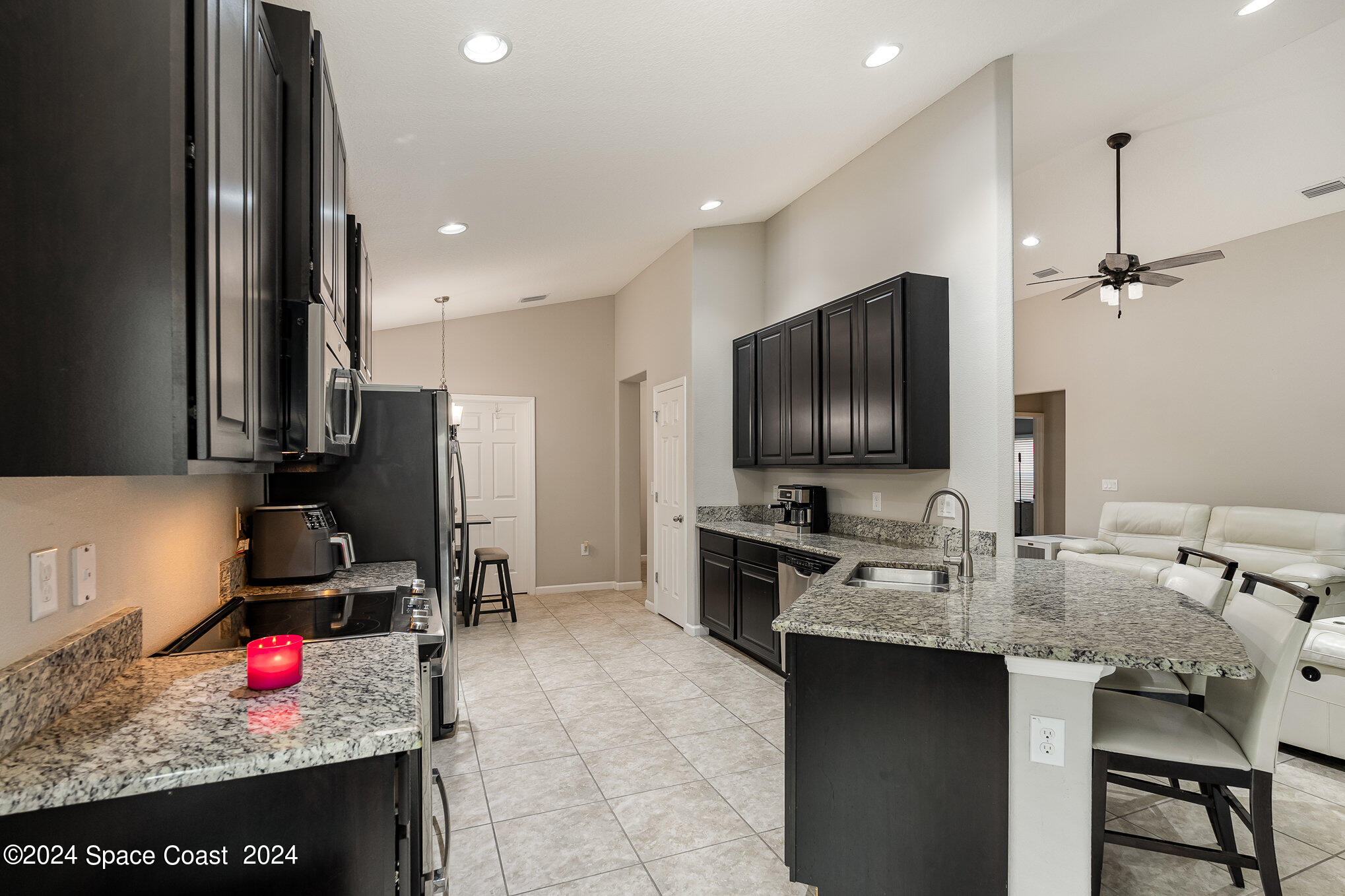 4210 Harvest Circle Rockledge, FL 32955 - Photo 9 of 24 a kitchen with granite countertop a sink stove and cabinets