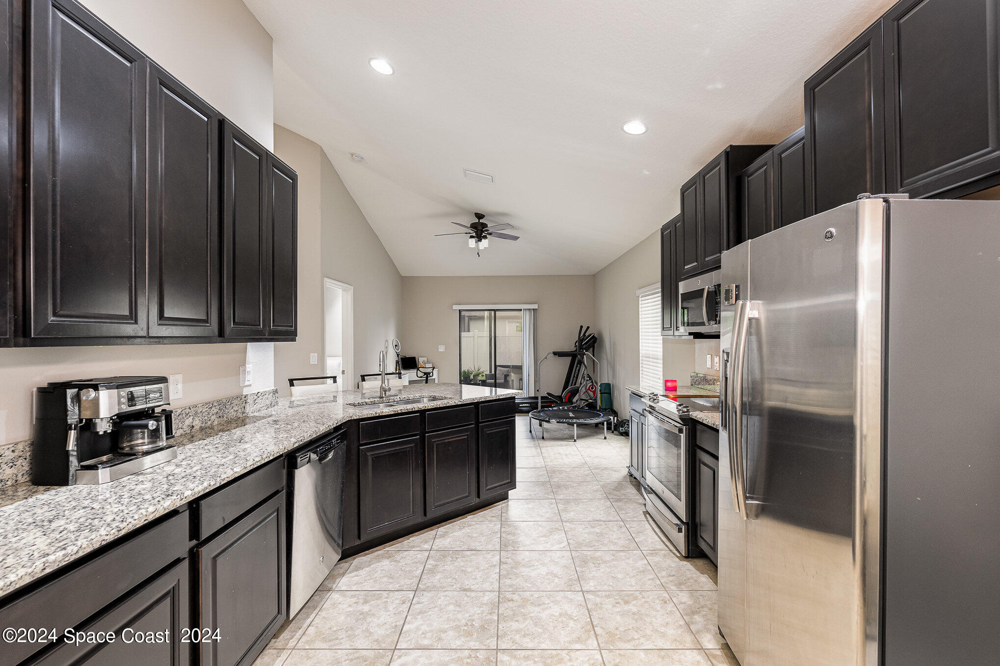 4210 Harvest Circle Rockledge, FL 32955 - Photo 10 of 24 a kitchen with a sink refrigerator and cabinets