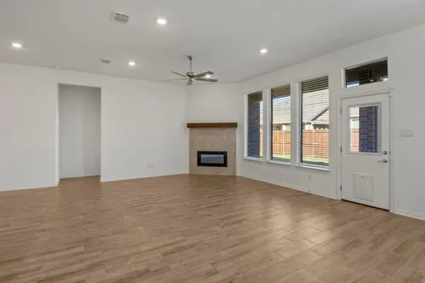 a view of an empty room with a fireplace and a window