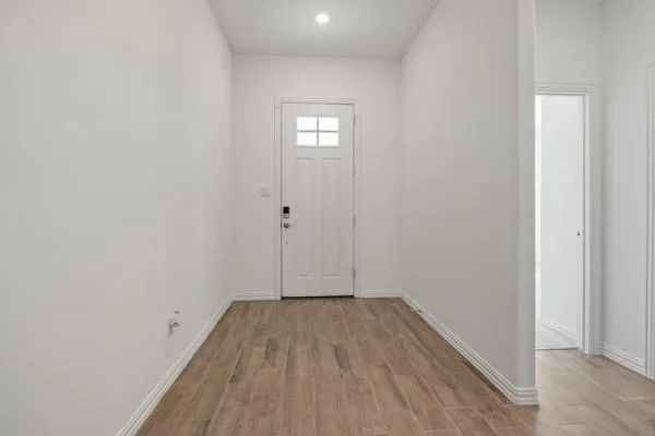 a view of a room with wooden floor and white walls