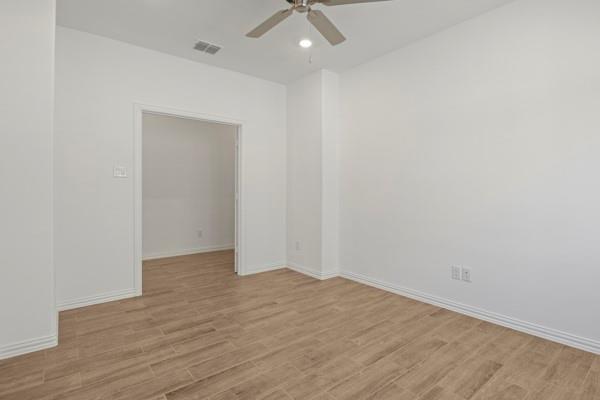224 Cherryvale Lane Princeton, TX 75407 - Photo 5 of 28 a view of an empty room with wooden floor and a ceiling fan