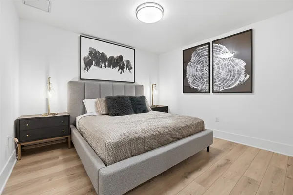 a bedroom with a bed and painting on the wall