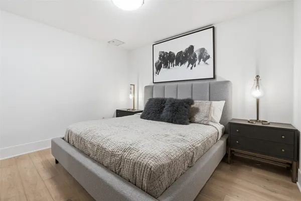 a bedroom with bed and painting on the wall