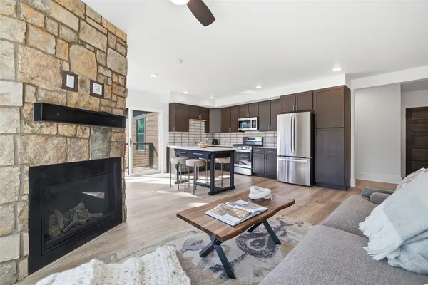 a living room with furniture a fireplace and kitchen view