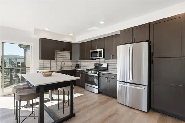 a kitchen with stainless steel appliances a refrigerator stove microwave and cabinets