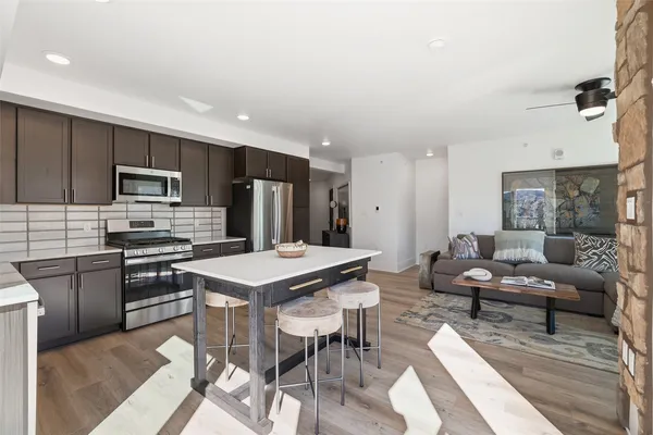 a kitchen with a table chairs refrigerator and microwave