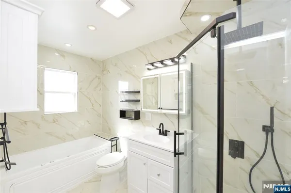 a bathroom with a sink a toilet and shower