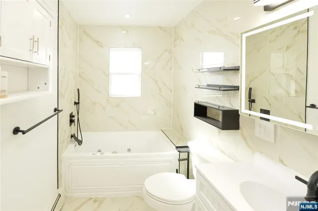 a bathroom with a bathtub toilet sink and shower