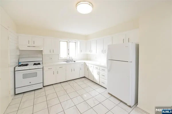 a kitchen with cabinets and white appliances