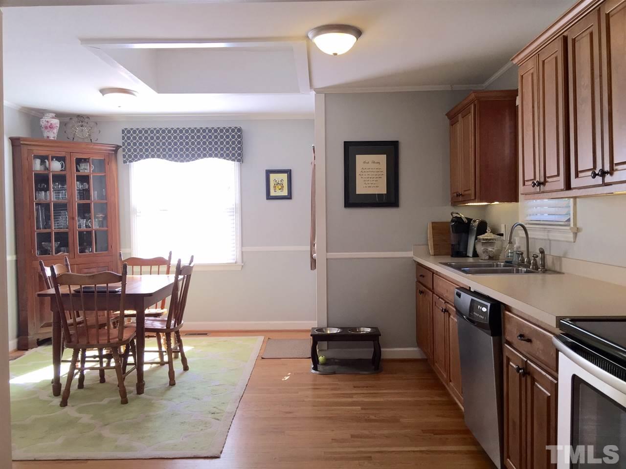 412 Colleton Road Raleigh, NC 27610 - Photo 7 of 19 a kitchen with stainless steel appliances granite countertop a stove top oven a sink a dining table and chairs