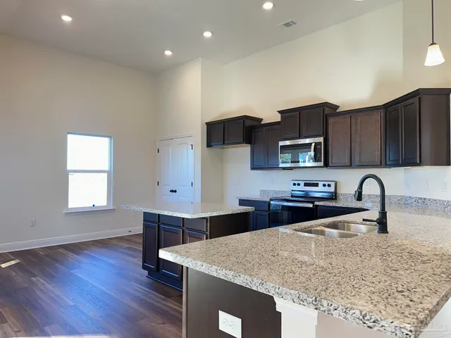 a kitchen with stainless steel appliances granite countertop a sink stove and microwave