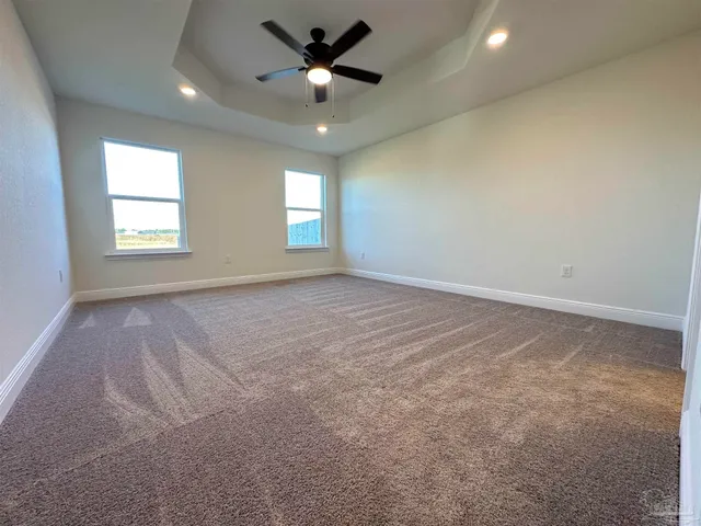 en empty room with windows and ceiling fan
