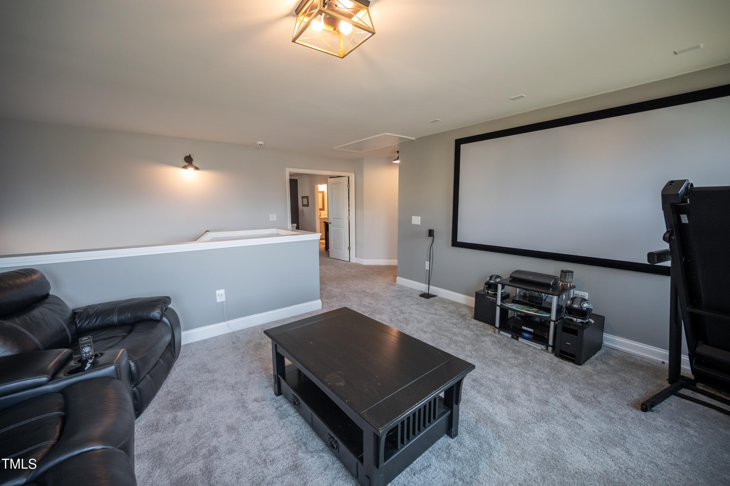357 Sunrise Ridge Drive Willow Spring, NC 27592 - Photo 18 of 35 a living room with furniture a flat screen tv and gym equipment